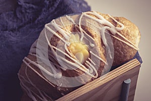 Fresh and tasty croissant with cream  selective focus on the blue natural textile . Tonned