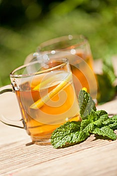 Fresh tasty hot tea lemon and mint outdoor in summer