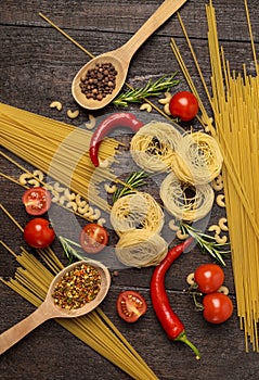 Fresh tasty ingredients for healthy cooking with spices, tomatoes, hot peppers and pasta