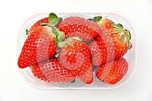 Fresh tasty large strawberries in a tray, top view on a white background