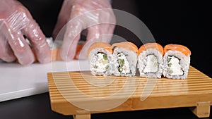 Fresh and tasty sushi rolls. Food video. served on wooden board. Hands putting sushi. Master sushi rolls puts sushi. hd