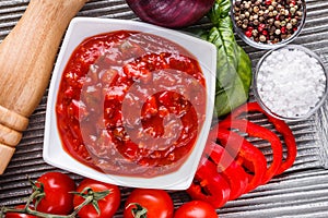 Fresh tasty tomato sauce on rustic wooden background