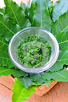 Fresh Thai herb mashed neem leaf on glass bowl.