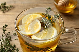 Fresh thyme tea with pieces of lemon on table, closeup