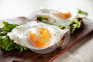 Fresh toasts with fried eggs and lettuce