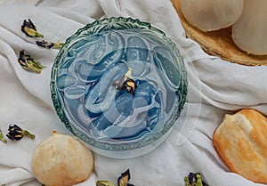 Fresh toddy palm in Blue butterfly pea syrup and shaved ice decorated with Dry butterfly pea flower served in Glass bowl