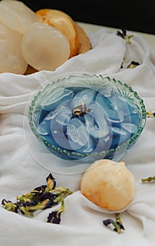 Fresh toddy palm in Blue butterfly pea syrup and shaved ice decorated with Dry butterfly pea flower served in Glass bowl