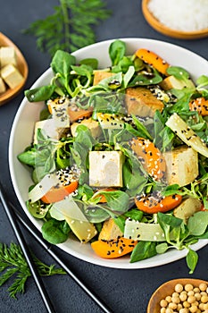 Fresh tofu salad with sesame seeds, corn salad, apricote and bamboo photo