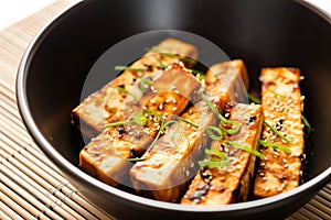 fresh tofu steaks in teriyaki marinade inside a bowl
