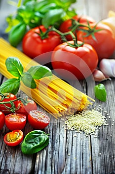 Fresh tomato and basil garnish on single serving of spaghetti, white background, food styling