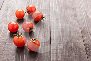 Fresh tomato on the brown wooden background. Top view