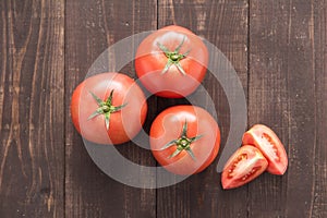 Fresh tomato on the brown wooden background. Top view