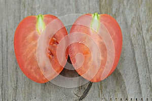 Fresh Tomato cut half on wooden background, decorate