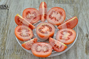 Fresh Tomato cut slices in plate on wooden background