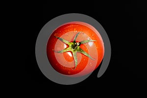 Fresh tomato isolated against black background. Organic tomato, top view
