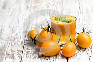 Fresh tomato juice made from the golden-yellow tomatoes in glass on the table