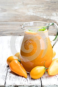 Fresh tomato juice made from the golden-yellow tomatoes in jar on the table
