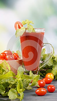 Fresh tomato juice with tomatoes and peppermint leave on table, Healthy food.