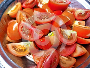 Fresh Tomato\'s Cut into Pieces and Ready before cock , red tomato\'s close up , put on Stainless Steel Round Tray Plate