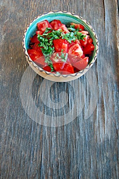 Fresh tomato salad with basil in ceramic bowl