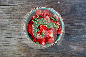 Fresh tomato salad with basil in ceramic bowl
