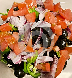 Fresh tomato salad with onions and black olives and jalapeno