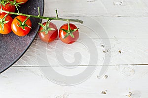 Fresh tomatoes on black plate