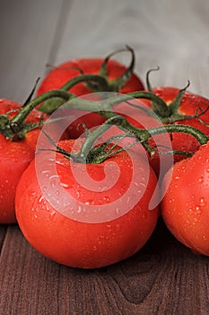 Fresh tomatoes on the brown wooden table