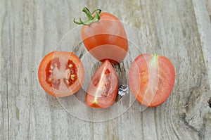 Fresh Tomatoes cut half on wooden background, decorate