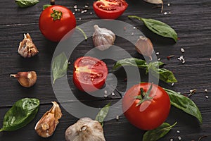 Fresh tomatoes and garlic closeup on dark rustic wood