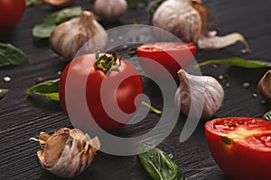 Fresh tomatoes and garlic closeup on dark rustic wood