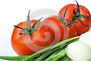 Fresh tomatoes with green onion, close up shot, isolated on white background. Gourmet food or healthy eating