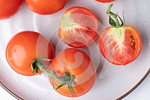 Fresh tomatoes on a green stem on white background