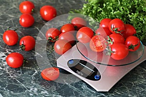 Fresh tomatoes on kitchen scales weighing