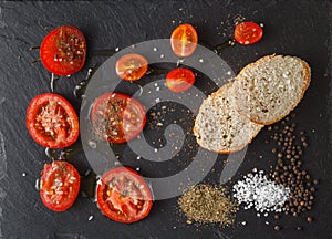 Fresh tomatoes with olive oil and salt. On black rustic backgrou