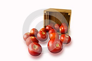 Fresh tomatoes on the vine and a cut one in a wooden crate on a