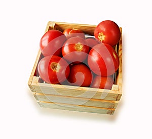 Fresh tomatoes on the vine in a wooden crate on a white backgrou