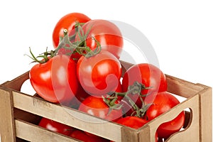 Fresh tomatoes in a wooden crate isolate on a white background