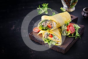 Fresh tortilla wraps with chicken and fresh vegetables on wooden board. Chicken burrito.