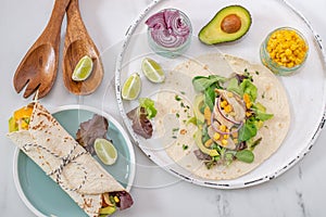 Fresh tortilla wraps with chicken, mushrooms and fresh vegetables on wooden board