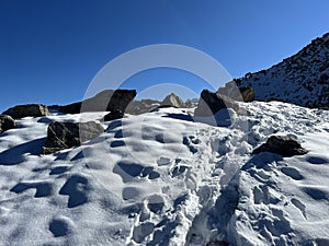 Fresh tracks on the season\'s first early autumn snow above the road pass Fluela (Fluelapass)