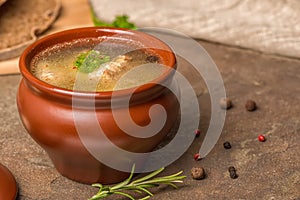 Fresh transparent fish soup with sturgeon, potatoes in clay plat