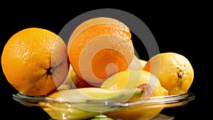 Fresh Tropical Fruit on Plate, Orange, Lemon, Banana. Spinning Close Up