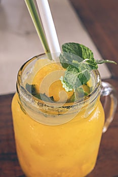 Fresh tropical fruit smoothie mango juice on wooden background, Bali island.