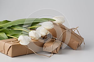 Fresh tulips and gift box over white background