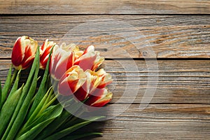 Fresh tulips on wooden background with space for text, flat lay.