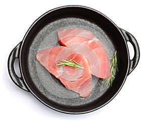 Fresh tuna Fish steak in black ceramic dish isolated on a white background