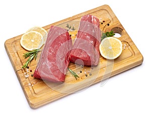 Fresh tuna Fish steak on a wooden cutting serving board isolated on a white background