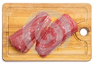 Fresh tuna Fish steak on a wooden cutting serving board isolated on a white background