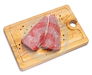 Fresh tuna Fish steak on a wooden cutting serving board isolated on a white background